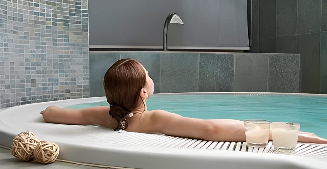 Woman relaxing in a spa jacuzzi bath.