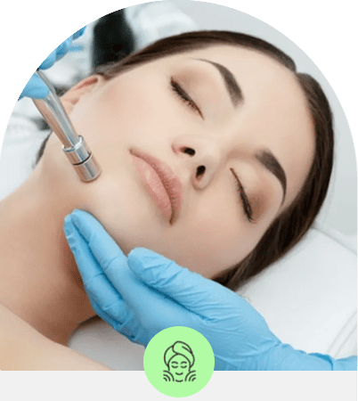 Woman receiving a facial treatment with a microdermabrasion tool.
