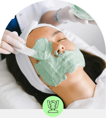 Person receiving a facial treatment with a green mask.