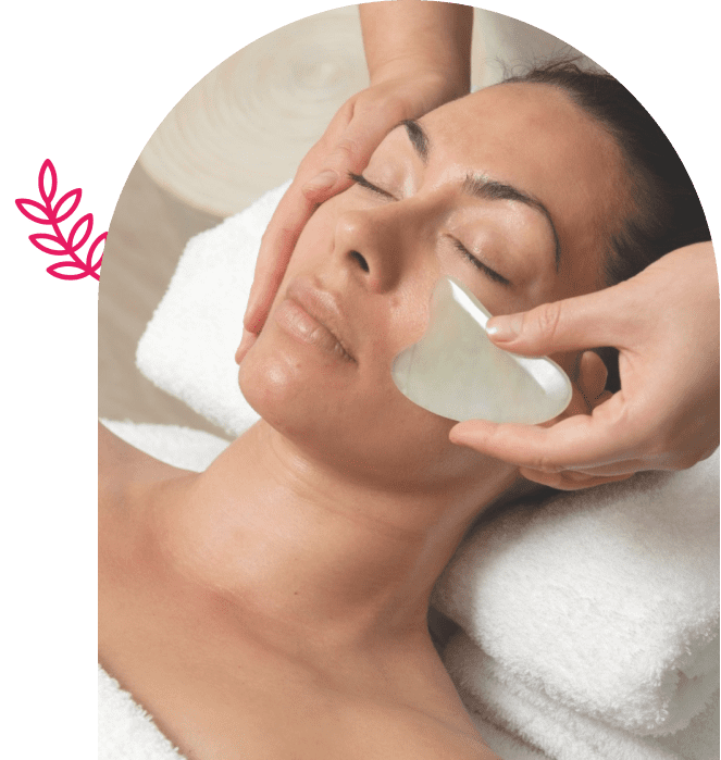 Woman receiving a relaxing facial massage with a jade roller.