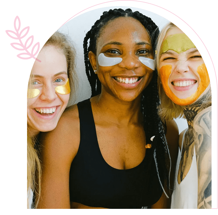 Three women smiling together against a bright pink background.