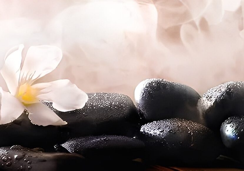 Steaming stones with flower in spa setting.