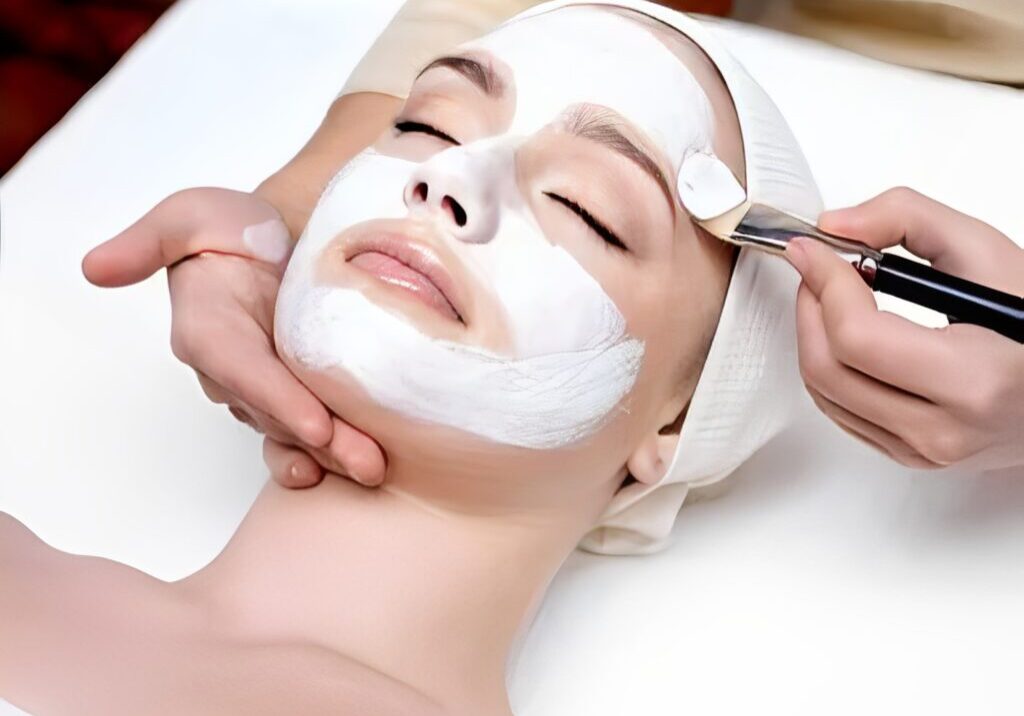 Woman receiving facial treatment with brush.